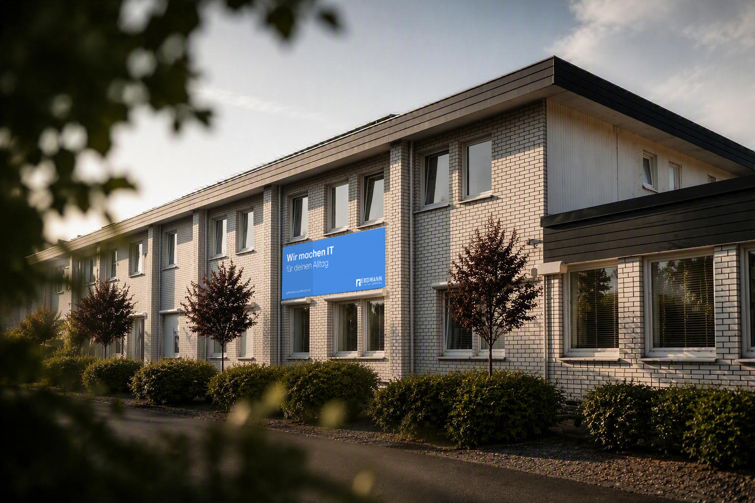 Firmengebäude von Systemhaus Erdmann in Solingen-Ohligs mit Banner „Wir machen IT für deinen Alltag“
