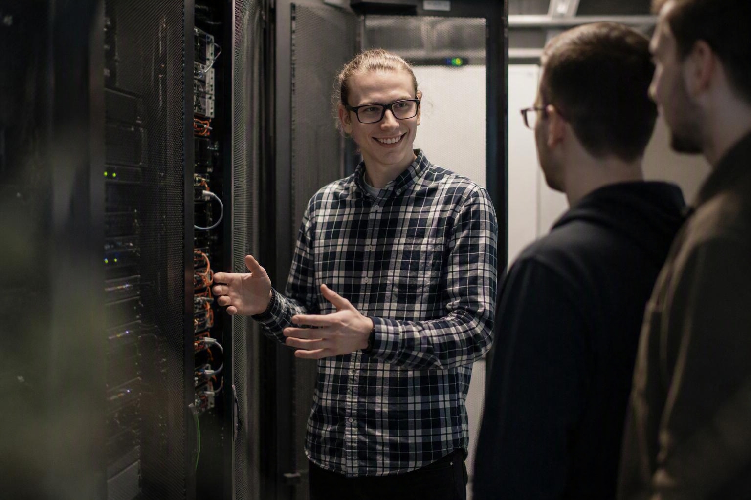 Kollege erklärt zwei Teammitgliedern die Technik im Serverraum